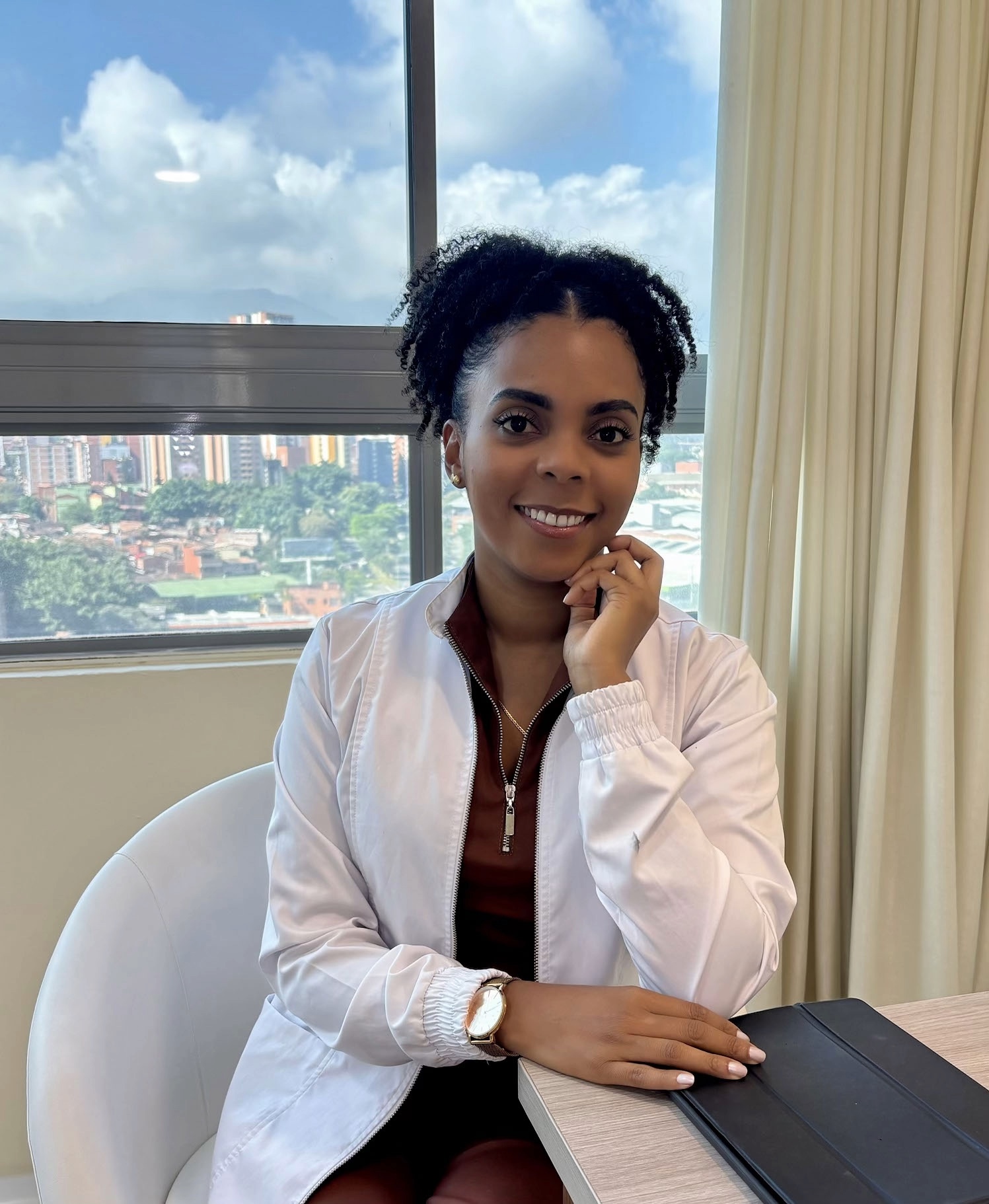 La Dra. Verónica Murillo sentada en su consultorio, con vista a Medellín